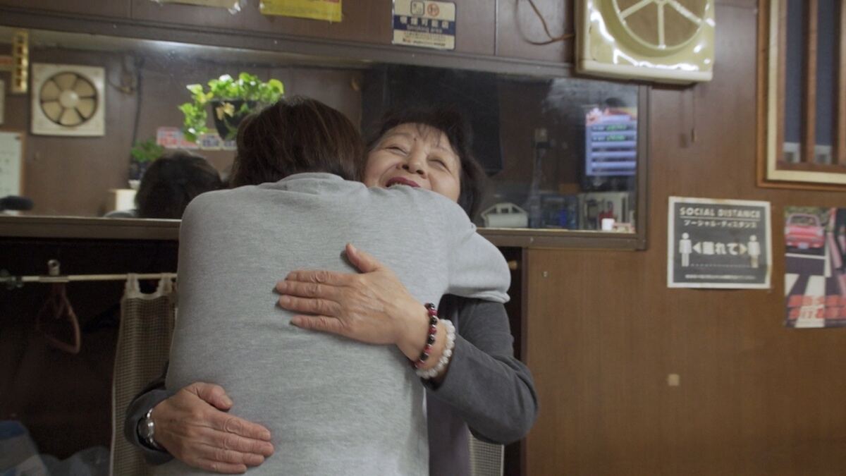 抱き合う塙山キャバレーのママと客　(C)フジテレビ