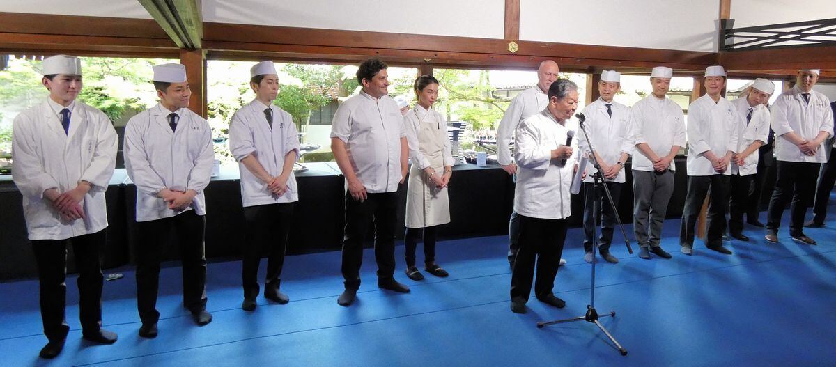 村田吉弘氏(前列)が参加したシェフ(後列)を紹介。左から、「魚三楼」 中村元紀氏、「萬亀楼」小西雄大氏、「京都吉兆」徳岡尚之氏、シェフ マウロ・コラグレコ氏、チェダリー・デバカム＝タム氏、カイル・コノートン氏、「木乃婦」髙橋拓児氏、「瓢亭」髙橋義弘氏、「菊乃井」村田知晴氏、「たん熊北店」栗栖熊一氏、「魚三楼」荒木裕一朗氏