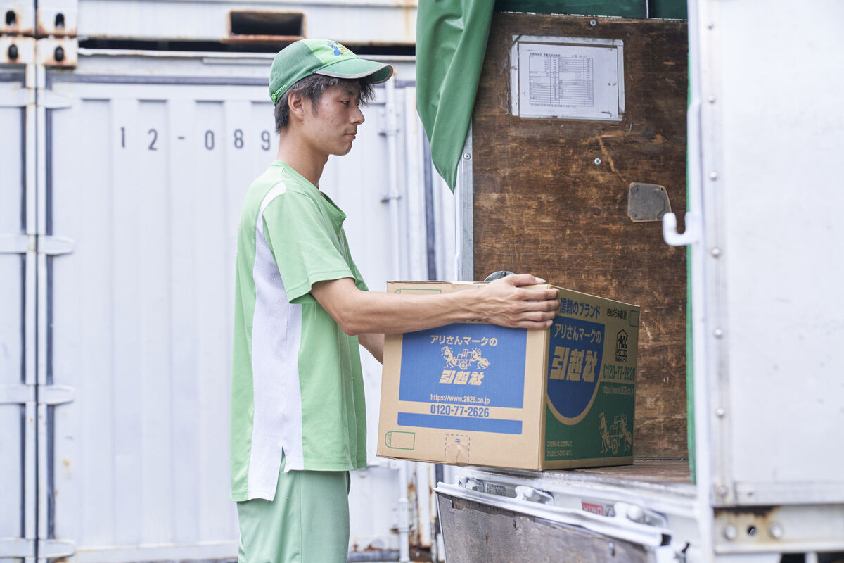 段ボールを荷台に積む白井さん