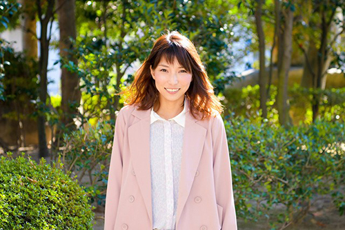 緑に囲まれ笑顔の芦村さん