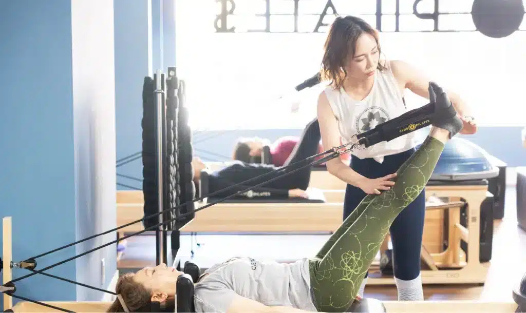 CLUB PILATESでマシンピラティスのレッスンを受ける女性