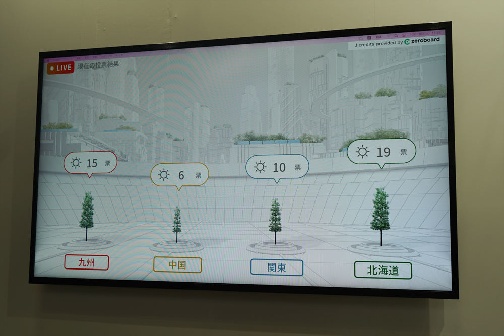 展示ブースでは選択された地域の木が成長する様子がリアルタイムで表示されている