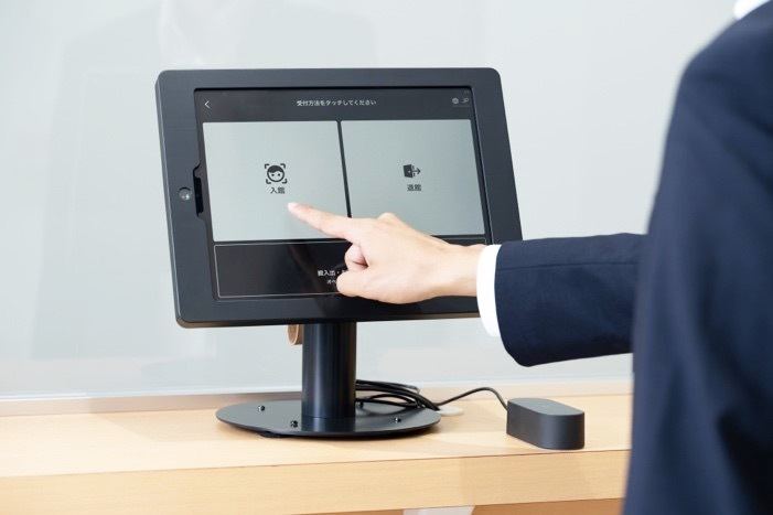 受付に設置されたタブレット上の案内に沿って、入退館手続きを行う（イメージ）