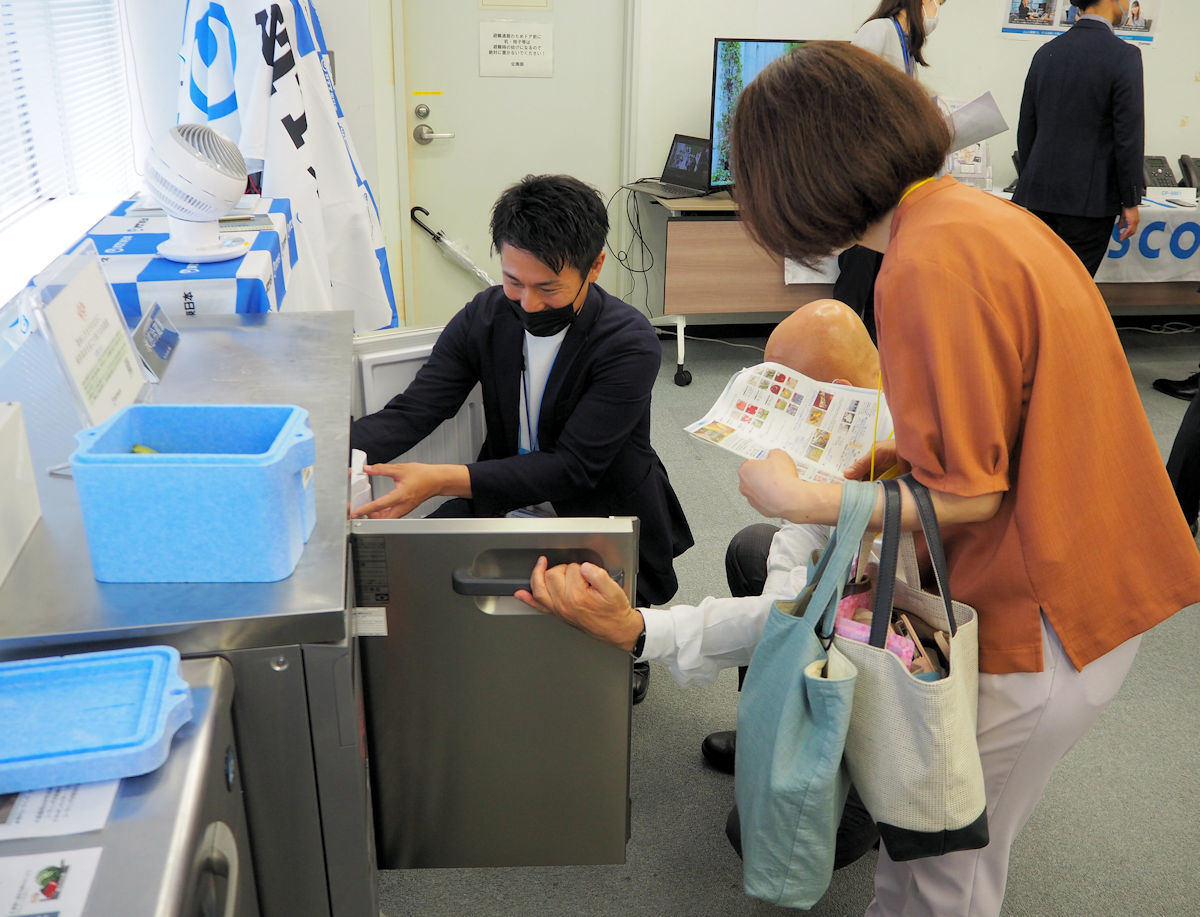 水産品仲卸業の夫婦が「電圧冷蔵庫」を確認する様子