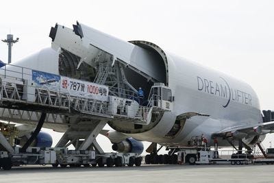 747LCFに積み込まれる787のウィングボックス。ローダーに掲げられた横断幕は、1,000機目の主翼が完成したことを祝うもの　撮影：井上孝司