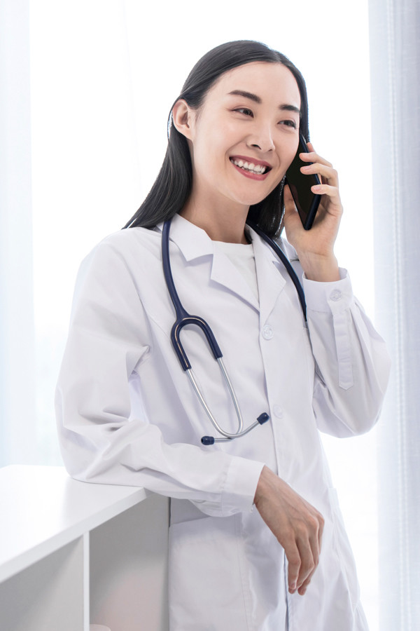 スマートフォンで通話をする女性医師