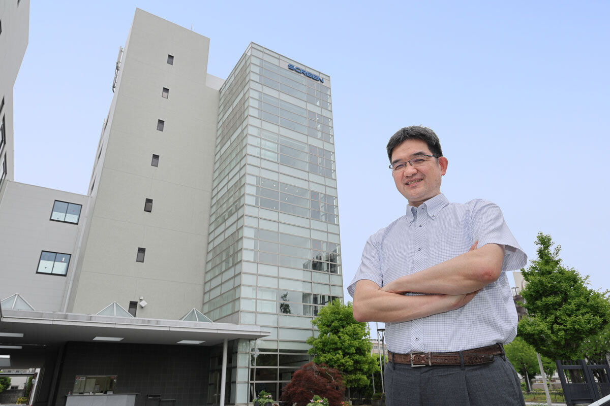 企業の建物を前にしたメインカット