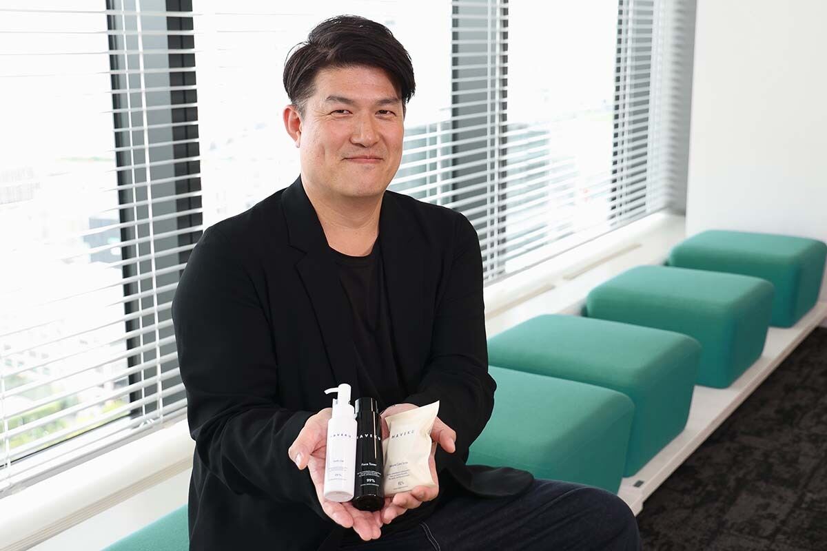 HAVEKUの化粧品を手に持つ笑顔の西山さん